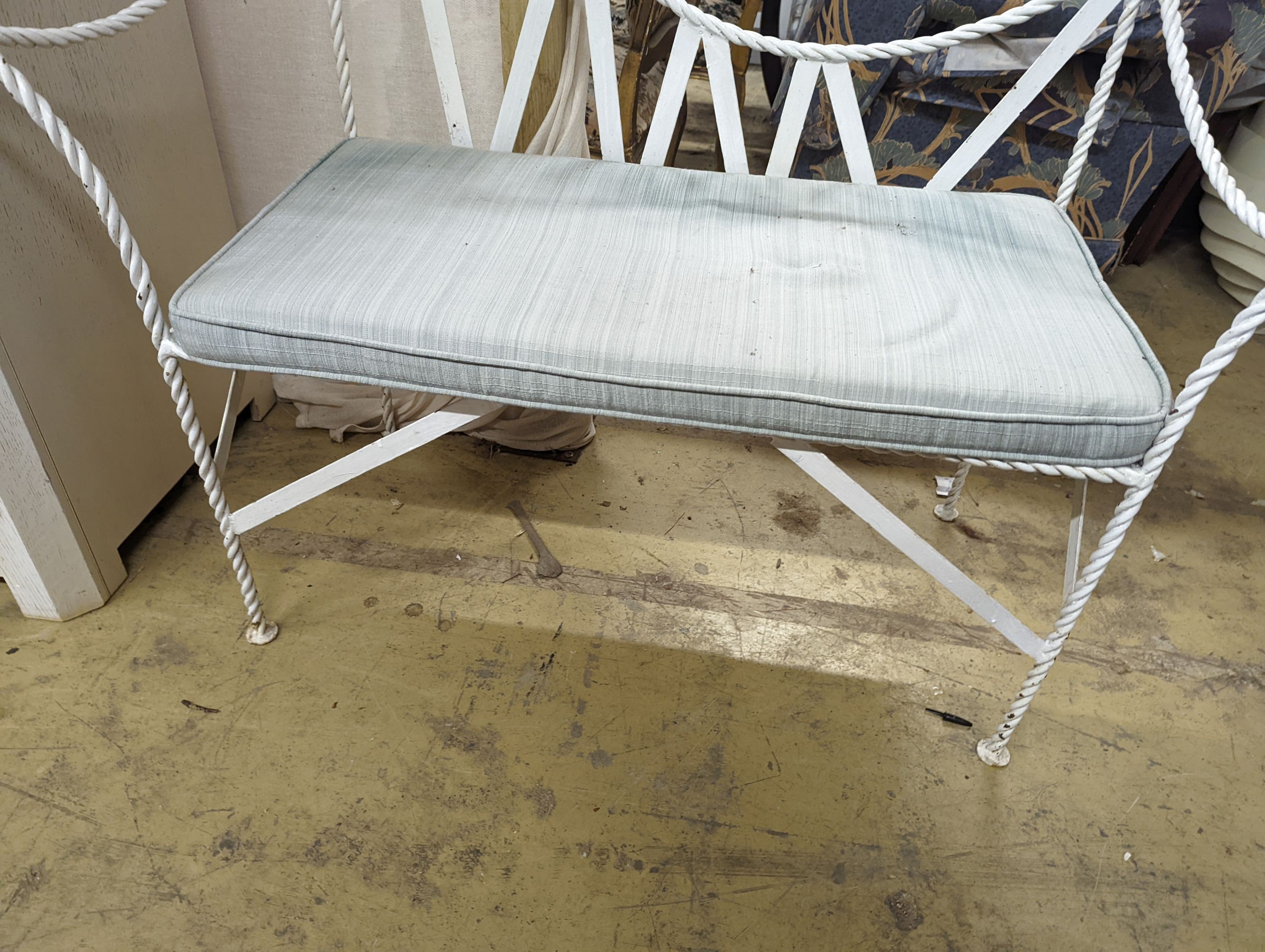 A wrought iron 'rope twist' seat with squab cushion, length 140cm, depth 54cm, height 132cm